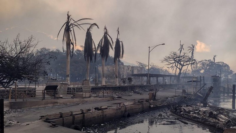 Orang-orang menyaksikan asap dan api memenuhi udara dari amukan kebakaran hutan di Front Street di pusat kota Lahaina, Maui pada Selasa, 8 Agustus 2023. Para pejabat Maui mengatakan kebakaran di kota bersejarah itu telah menghanguskan sebagian dari salah satu kawasan wisata paling populer di Hawaii. . Juru bicara County of Maui, Mahina Martin mengatakan dalam sebuah wawancara telepon pada Rabu pagi, kebakaran meluas di Lahaina, termasuk Front Street, area kota yang populer dengan turis. (Alan Dickar via AP)