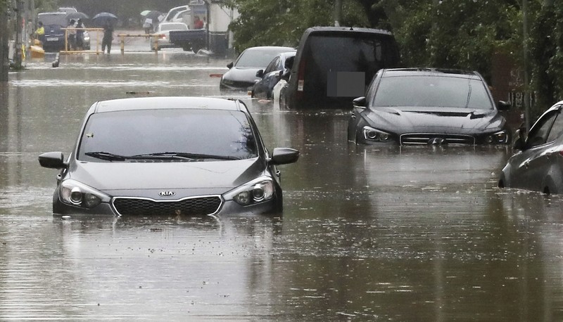 South Korea Asia Storm People struggle in the rain and wind as the tropical storm named Khanun approaches to the Korean Peninsular, in Busan, Thursday, Aug. 10, 2023. (AP Photo/Ahn Young-joon)