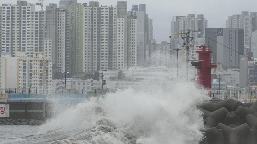 People struggle in the rain and wind as the tropical storm named Khanun approaches to the Korean Peninsular, in Busan, Thursday, Aug. 10, 2023. (AP Photo/Ahn Young-joon)