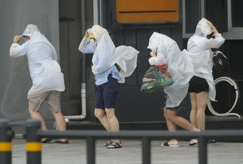 South Korea Asia Storm People struggle in the rain and wind as the tropical storm named Khanun approaches to the Korean Peninsular, in Busan, Thursday, Aug. 10, 2023. (AP Photo/Ahn Young-joon)