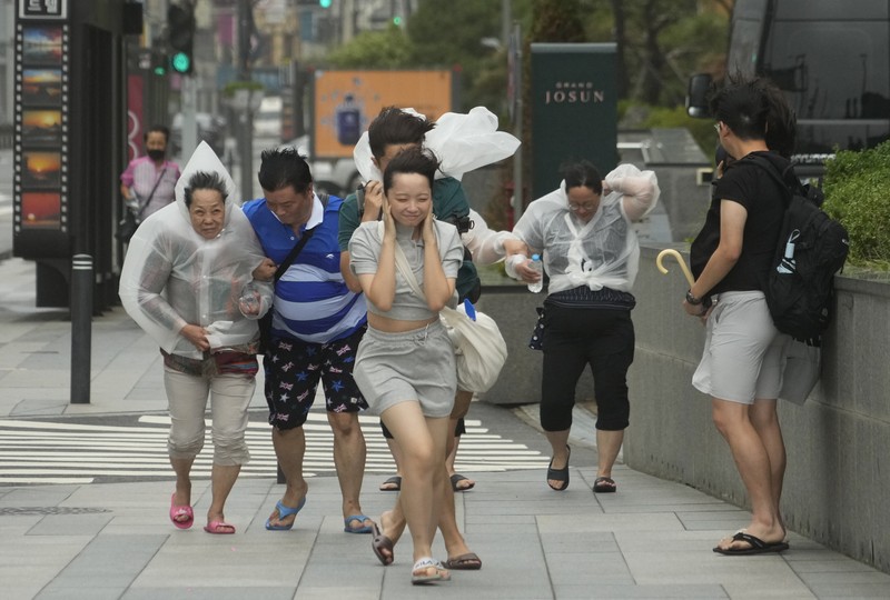 South Korea Asia Storm People struggle in the rain and wind as the tropical storm named Khanun approaches to the Korean Peninsular, in Busan, Thursday, Aug. 10, 2023. (AP Photo/Ahn Young-joon)