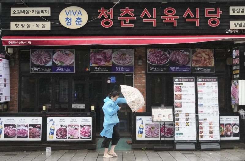 South Korea Asia Storm People struggle in the rain and wind as the tropical storm named Khanun approaches to the Korean Peninsular, in Busan, Thursday, Aug. 10, 2023. (AP Photo/Ahn Young-joon)