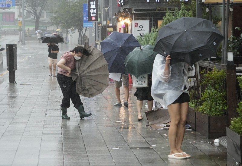 South Korea Asia Storm People struggle in the rain and wind as the tropical storm named Khanun approaches to the Korean Peninsular, in Busan, Thursday, Aug. 10, 2023. (AP Photo/Ahn Young-joon)