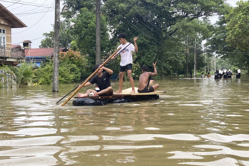 Penduduk setempat menaiki rakit yang terbuat dari ban dalam di sepanjang jalan yang banjir di Bago, Myanmar, sekitar 80 kilometer (50 mil) timur laut Yangon, Jumat, 11 Agustus 2023. Penduduk setempat menaiki rakit yang terbuat dari ban dalam di sepanjang jalan yang banjir di Bago, Myanmar, sekitar 80 kilometer (50 mil) timur laut Yangon, Jumat, 11 Agustus 2023. (AP Photo)