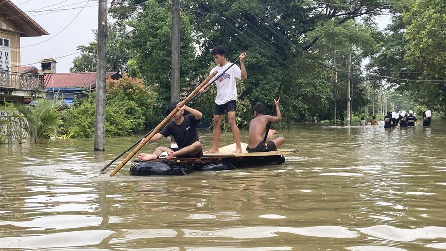 Penduduk setempat menaiki rakit yang terbuat dari ban dalam di sepanjang jalan yang banjir di Bago, Myanmar, sekitar 80 kilometer (50 mil) timur laut Yangon, Jumat, 11 Agustus 2023. (AP Photo)