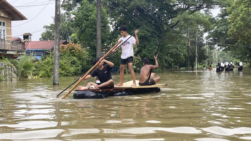 Penduduk setempat menaiki rakit yang terbuat dari ban dalam di sepanjang jalan yang banjir di Bago, Myanmar, sekitar 80 kilometer (50 mil) timur laut Yangon, Jumat, 11 Agustus 2023. (AP Photo)