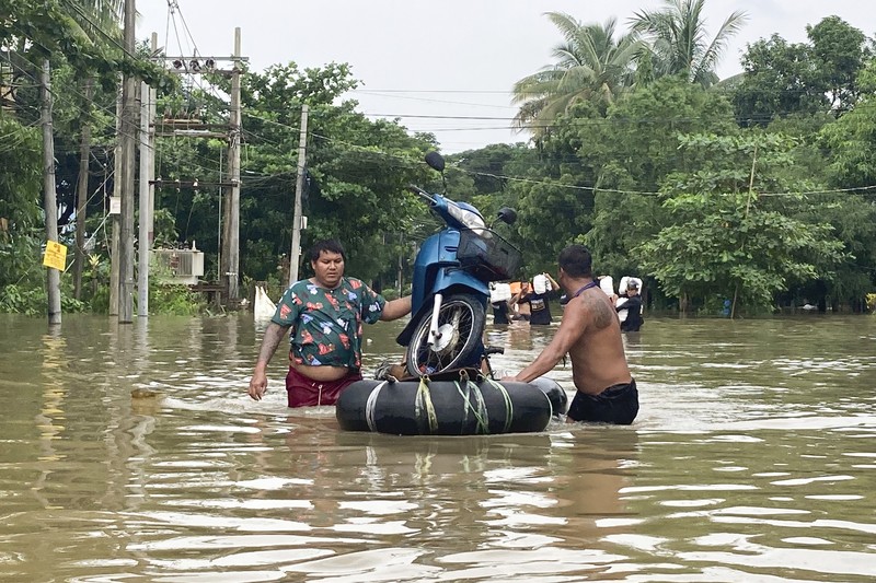 Penduduk setempat menaiki rakit yang terbuat dari ban dalam di sepanjang jalan yang banjir di Bago, Myanmar, sekitar 80 kilometer (50 mil) timur laut Yangon, Jumat, 11 Agustus 2023. (AP Photo)