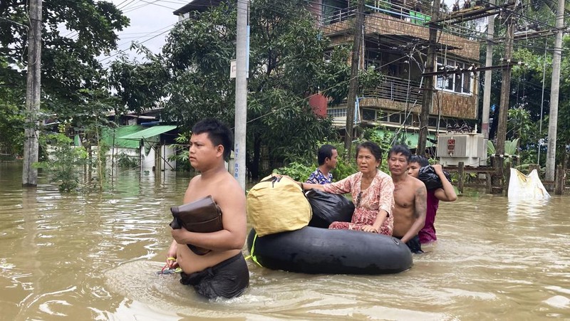 Penduduk setempat menaiki rakit yang terbuat dari ban dalam di sepanjang jalan yang banjir di Bago, Myanmar, sekitar 80 kilometer (50 mil) timur laut Yangon, Jumat, 11 Agustus 2023. (AP Photo)