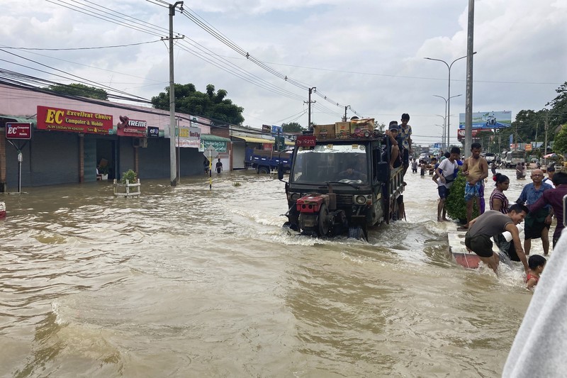 Penduduk setempat menaiki rakit yang terbuat dari ban dalam di sepanjang jalan yang banjir di Bago, Myanmar, sekitar 80 kilometer (50 mil) timur laut Yangon, Jumat, 11 Agustus 2023. Penduduk setempat menaiki rakit yang terbuat dari ban dalam di sepanjang jalan yang banjir di Bago, Myanmar, sekitar 80 kilometer (50 mil) timur laut Yangon, Jumat, 11 Agustus 2023. (AP Photo)