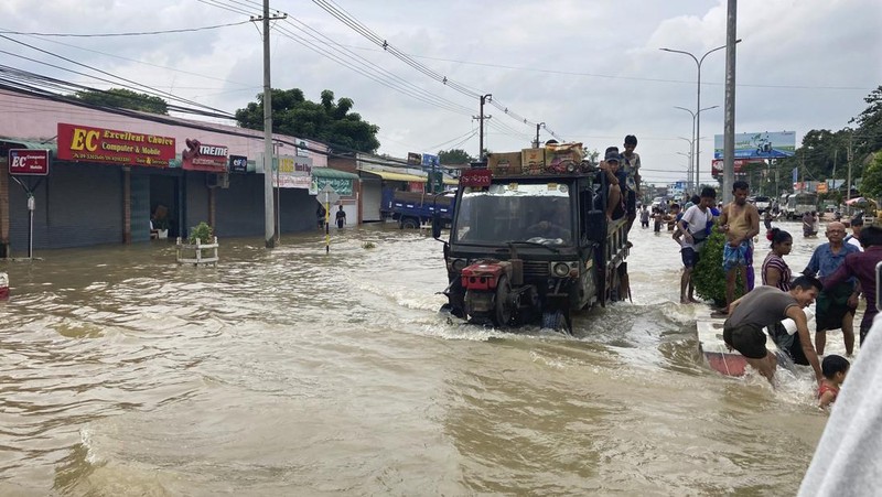 Penduduk setempat menaiki rakit yang terbuat dari ban dalam di sepanjang jalan yang banjir di Bago, Myanmar, sekitar 80 kilometer (50 mil) timur laut Yangon, Jumat, 11 Agustus 2023. (AP Photo)