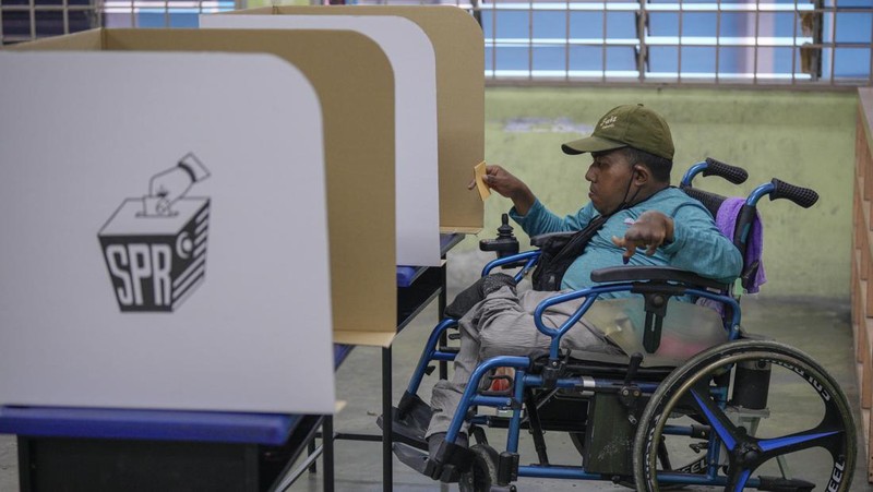 Orang-orang mengantre untuk memberikan suara mereka selama pemilihan negara bagian di Selayang, Malaysia 12 Agustus 2023. (REUTERS/Hasnoor Hussain)