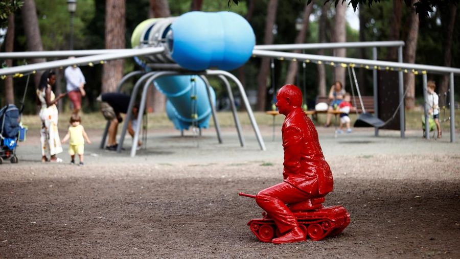 Anak-anak menyentuh patung Presiden Rusia Vladimir Putin seukuran manusia mengendarai tank kecil yang dibuat oleh seniman Prancis James Colomina di Villa Borghese di Roma, Italia, 3 Agustus 2023. (REUTERS/Yara Nardi)