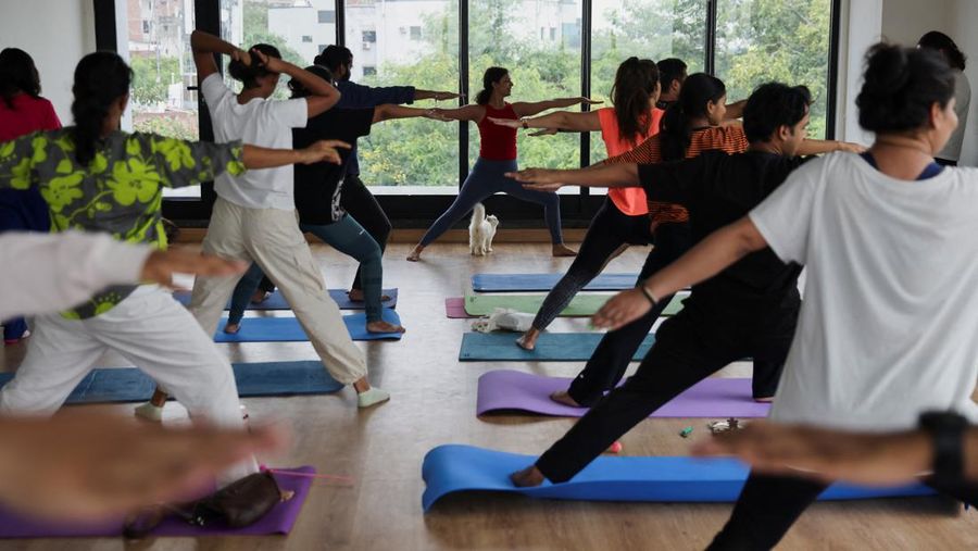 Peserta melakukan yoga saat anak kucing bermain di sekitar mereka dalam sesi yoga yang diselenggarakan oleh Pawhour, di sebuah studio di New Delhi, India, 6 Agustus 2023. (REUTERS/Anushree Fadnavis)