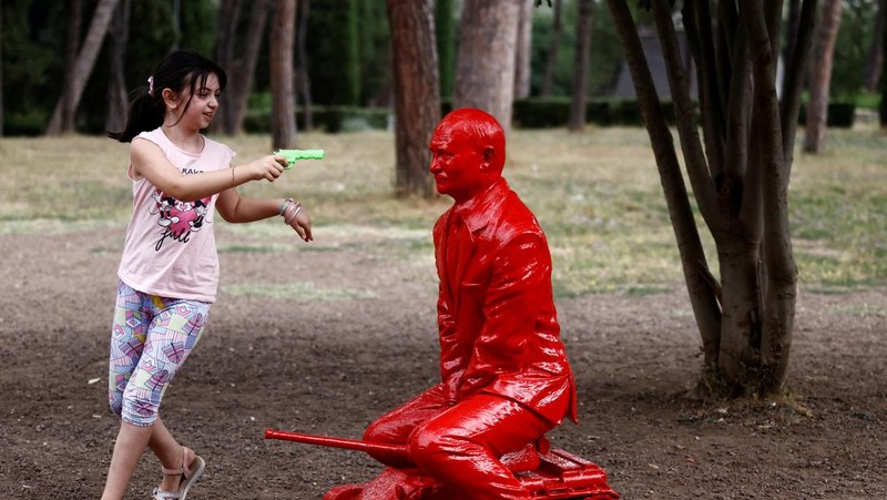 Anak-anak menyentuh patung Presiden Rusia Vladimir Putin seukuran manusia mengendarai tank kecil yang dibuat oleh seniman Prancis James Colomina di Villa Borghese di Roma, Italia, 3 Agustus 2023. (REUTERS/Yara Nardi)