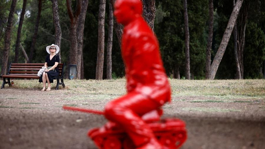 Anak-anak menyentuh patung Presiden Rusia Vladimir Putin seukuran manusia mengendarai tank kecil yang dibuat oleh seniman Prancis James Colomina di Villa Borghese di Roma, Italia, 3 Agustus 2023. (REUTERS/Yara Nardi)
