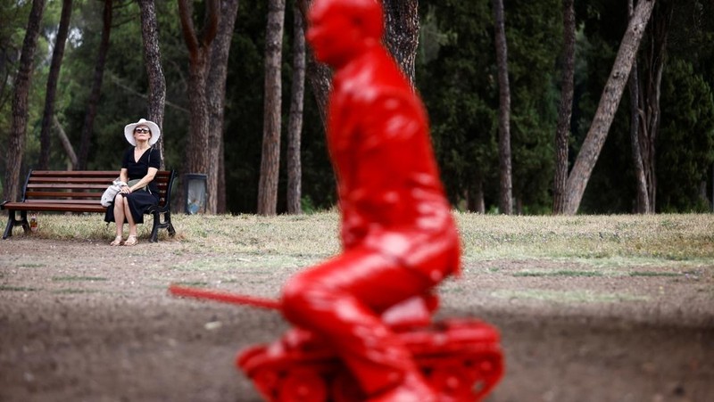 Anak-anak menyentuh patung Presiden Rusia Vladimir Putin seukuran manusia mengendarai tank kecil yang dibuat oleh seniman Prancis James Colomina di Villa Borghese di Roma, Italia, 3 Agustus 2023. (REUTERS/Yara Nardi)