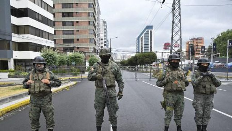 Ecuadorian soldiers stand guard outside the Ecuador TV headquarters before the beginning of the presidential debate in Quito, on August 13, 2023. (Photo by Rodrigo BUENDIA / AFP)
