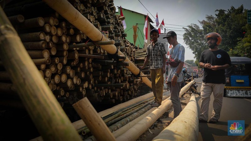 Pengrajin menyelesaikan pembuatan batang pinang untuk perlombaan HUT RI, Manggarai, Jakarta, Senin (14/8/2023). (CNBC Indonesia/Faisal Rahman)