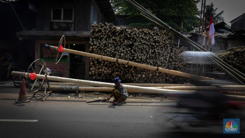 Pengrajin menyelesaikan pembuatan batang pinang untuk perlombaan HUT RI, Manggarai, Jakarta, Senin (14/8/2023). (CNBC Indonesia/Faisal Rahman)