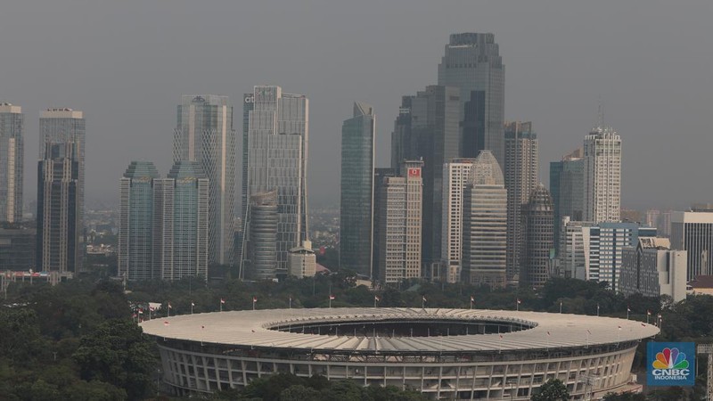 Sejumlah karyawan melihat gedung bertingkat yang tertutup oleh kabut polusi di Jakarta, Senin, (14/8). (CNBC Indonesia/Muhammad Sabki)