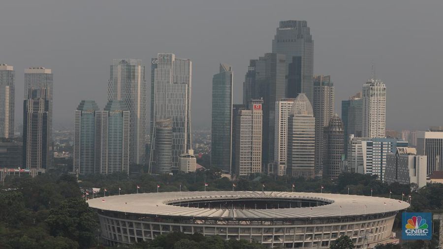 Sejumlah karyawan melihat gedung bertingkat yang tertutup oleh kabut polusi di Jakarta, Senin, (14/8). (CNBC Indonesia/Muhammad Sabki)