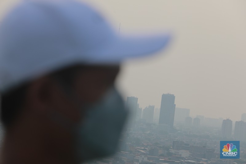 Sejumlah karyawan melihat gedung bertingkat yang tertutup oleh kabut polusi di Jakarta, Senin, (14/8). Sejumlah karyawan melihat gedung bertingkat yang tertutup oleh kabut polusi di Jakarta, Senin, (14/8). (CNBC Indonesia/Muhammad Sabki)