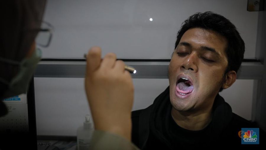Dokter melakukan pemeriksaan kesehatan terhadap pasien bergejala Infeksi Saluran Pernapasan Akut (ISPA) di Puskesmas Kecamatan Mampang Prapatan, Jakarta Selatan, Selasa (15/8/2023). Tingginya angka polusi udara di Jakarta belakangan ini menyebabkan jumlah warga yang terinfeksi penyakit ISPA meningkat. (CNBC Indonesia/Faisal Rahman)