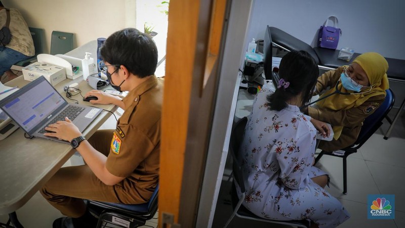 Dokter melakukan pemeriksaan kesehatan terhadap pasien bergejala Infeksi Saluran Pernapasan Akut (ISPA) di Puskesmas Kecamatan Mampang Prapatan, Jakarta Selatan, Selasa (15/8/2023). Tingginya angka polusi udara di Jakarta belakangan ini menyebabkan jumlah warga yang terinfeksi penyakit ISPA meningkat. (CNBC Indonesia/Faisal Rahman)