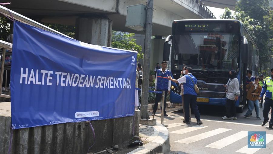 Sejumlah pekerja memasang karpet untuk halte sementara yang berada di sekitar lokasi Halte Tendean, Jakarta Selatan pada Selasa (15/8/2023) usai terbakar kemarin sore. (վ/Tias Budiarto)