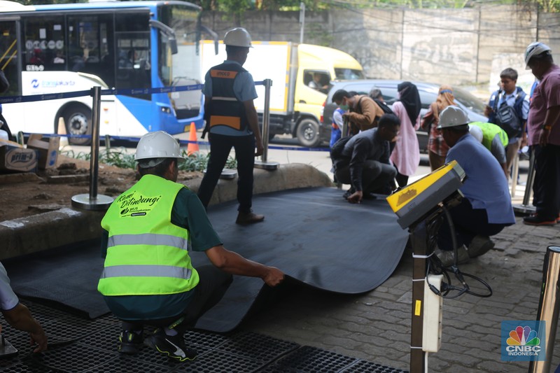 Sejumlah pekerja memasang karpet untuk halte sementara yang berada di sekitar lokasi Halte Tendean, Jakarta Selatan pada Selasa (15/8/2023) usai terbakar kemarin sore. Sejumlah pekerja memasang karpet untuk halte sementara yang berada di sekitar lokasi Halte Tendean, Jakarta Selatan pada Selasa (15/8/2023) usai terbakar kemarin sore. (CNBC Indonesia/Tias Budiarto)