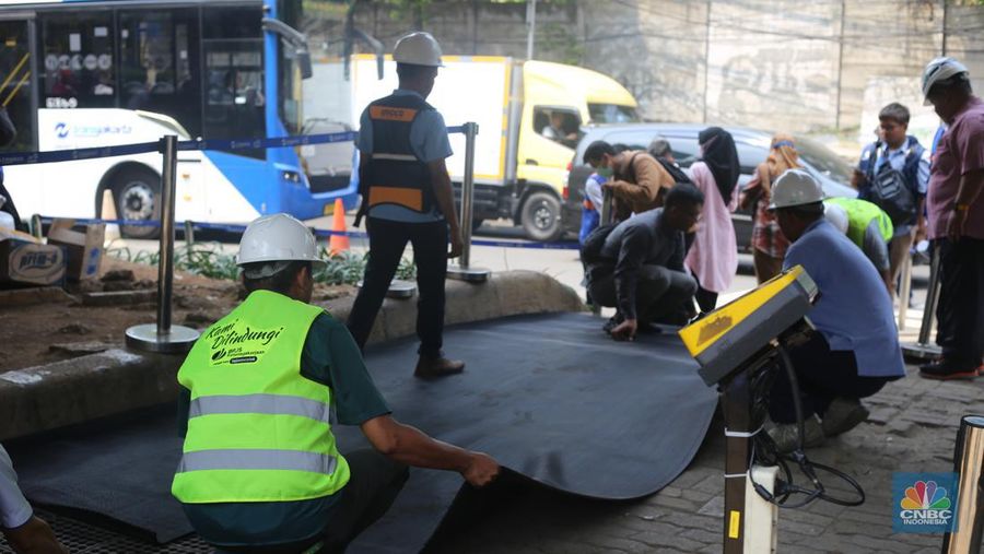 Sejumlah pekerja memasang karpet untuk halte sementara yang berada di sekitar lokasi Halte Tendean, Jakarta Selatan pada Selasa (15/8/2023) usai terbakar kemarin sore. (վ/Tias Budiarto)