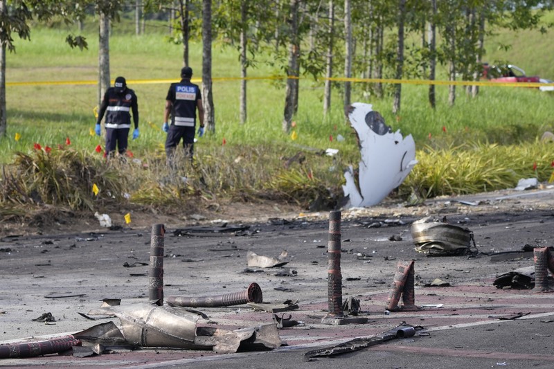 Seorang anggota departemen pemadam kebakaran dan penyelamatan memeriksa lokasi jatuhnya pesawat kecil di distrik Shah Alam, Malaysia, Kamis, 17 Agustus 2023. Polisi mengatakan sebuah pesawat kecil jatuh di pinggiran negara bagian Selangor tengah Malaysia, dengan banyak jenazah pulih. (AP Photo/Vincent Thian)