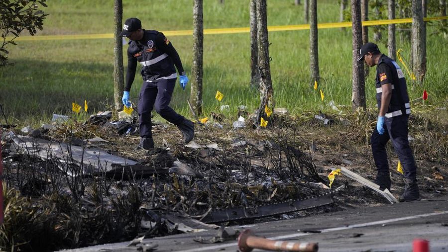Seorang anggota departemen pemadam kebakaran dan penyelamatan memeriksa lokasi jatuhnya pesawat kecil di distrik Shah Alam, Malaysia, Kamis, 17 Agustus 2023. Polisi mengatakan sebuah pesawat kecil jatuh di pinggiran negara bagian Selangor tengah Malaysia, dengan banyak jenazah pulih. (AP Photo/Vincent Thian)