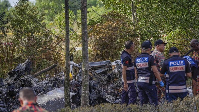 Seorang anggota departemen pemadam kebakaran dan penyelamatan memeriksa lokasi jatuhnya pesawat kecil di distrik Shah Alam, Malaysia, Kamis, 17 Agustus 2023. Polisi mengatakan sebuah pesawat kecil jatuh di pinggiran negara bagian Selangor tengah Malaysia, dengan banyak jenazah pulih. (AP Photo/Vincent Thian)