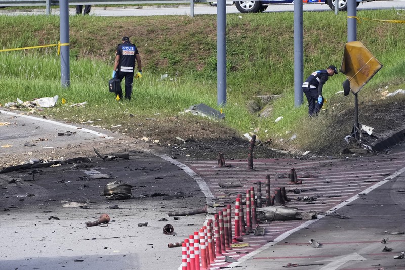 Seorang anggota departemen pemadam kebakaran dan penyelamatan memeriksa lokasi jatuhnya pesawat kecil di distrik Shah Alam, Malaysia, Kamis, 17 Agustus 2023. Polisi mengatakan sebuah pesawat kecil jatuh di pinggiran negara bagian Selangor tengah Malaysia, dengan banyak jenazah pulih. (AP Photo/Vincent Thian)