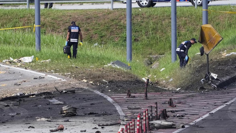 Seorang anggota departemen pemadam kebakaran dan penyelamatan memeriksa lokasi jatuhnya pesawat kecil di distrik Shah Alam, Malaysia, Kamis, 17 Agustus 2023. Polisi mengatakan sebuah pesawat kecil jatuh di pinggiran negara bagian Selangor tengah Malaysia, dengan banyak jenazah pulih. (AP Photo/Vincent Thian)