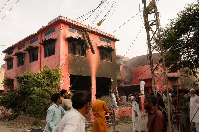 Seorang pengunjuk rasa berdiri di atap sebuah gereja merusak struktur bangunan di Jaranwala, Pakistan 16 Agustus 2023. (REUTERS TV via REUTERS)