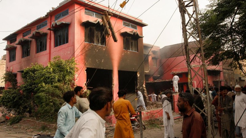 Seorang pengunjuk rasa berdiri di atap sebuah gereja merusak struktur bangunan di Jaranwala, Pakistan 16 Agustus 2023. (REUTERS TV via REUTERS)