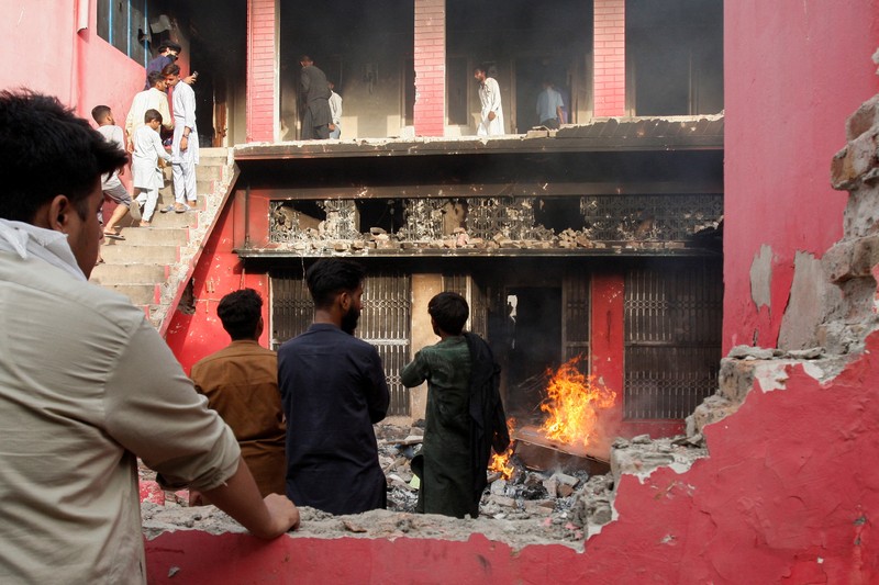 Seorang pengunjuk rasa berdiri di atap sebuah gereja merusak struktur bangunan di Jaranwala, Pakistan 16 Agustus 2023. Seorang pengunjuk rasa berdiri di atap sebuah gereja merusak struktur bangunan di Jaranwala, Pakistan 16 Agustus 2023. (REUTERS TV via REUTERS)
