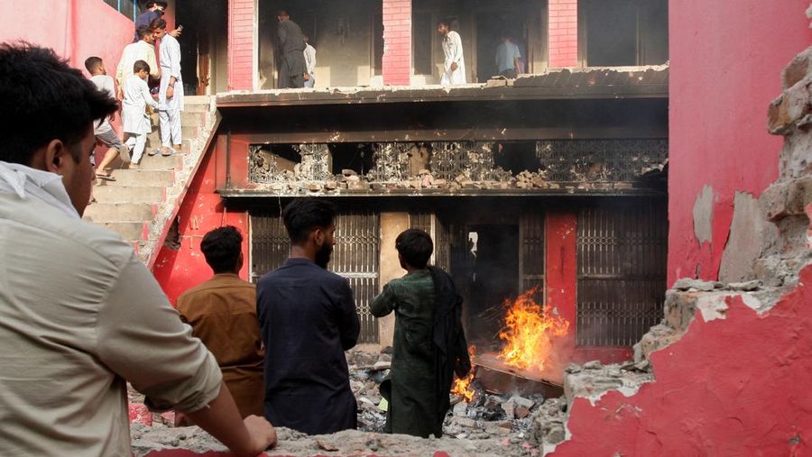 Seorang pengunjuk rasa berdiri di atap sebuah gereja merusak struktur bangunan di Jaranwala, Pakistan 16 Agustus 2023. (REUTERS TV via REUTERS)