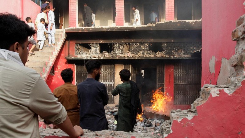 Seorang pengunjuk rasa berdiri di atap sebuah gereja merusak struktur bangunan di Jaranwala, Pakistan 16 Agustus 2023. (REUTERS TV via REUTERS)