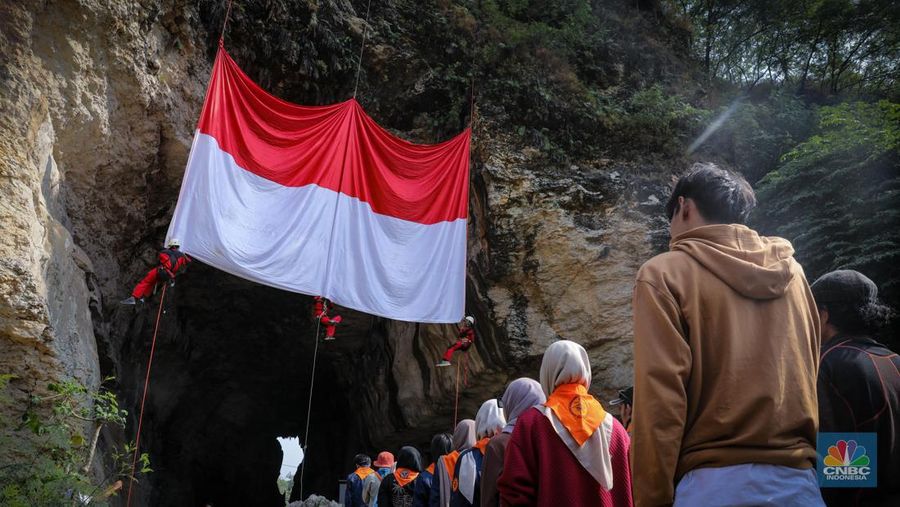 Pegiat alam bebas mengibarkan bendera merah putih pada HUT ke-78 RI di lokasi bekas tambang kapur, Tebing Arpam, Gua Sigugula, Klapanunggal, Kabupaten Bogor, Jawa Barat, Kamis (17/8/2023). (CNBC Indonesia/Faisal Rahman)