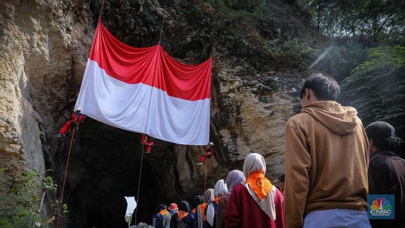 Pegiat alam bebas mengibarkan bendera merah putih pada HUT ke-78 RI di lokasi bekas tambang kapur, Tebing Arpam, Gua Sigugula, Klapanunggal, Kabupaten Bogor, Jawa Barat, Kamis (17/8/2023). (CNBC Indonesia/Faisal Rahman)