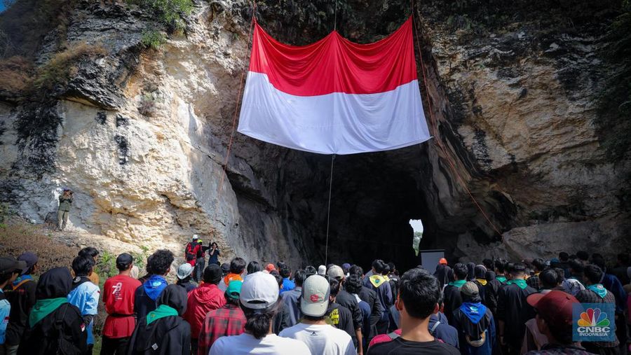 Pegiat alam bebas mengibarkan bendera merah putih pada HUT ke-78 RI di lokasi bekas tambang kapur, Tebing Arpam, Gua Sigugula, Klapanunggal, Kabupaten Bogor, Jawa Barat, Kamis (17/8/2023). (CNBC Indonesia/Faisal Rahman)