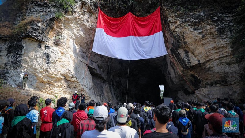Pegiat alam bebas mengibarkan bendera merah putih pada HUT ke-78 RI di lokasi bekas tambang kapur, Tebing Arpam, Gua Sigugula, Klapanunggal, Kabupaten Bogor, Jawa Barat, Kamis (17/8/2023). (CNBC Indonesia/Faisal Rahman)