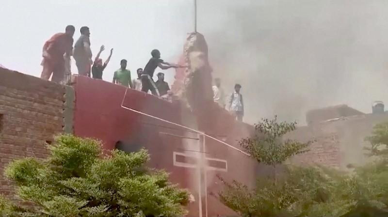 Seorang pengunjuk rasa berdiri di atap sebuah gereja merusak struktur bangunan di Jaranwala, Pakistan 16 Agustus 2023. Seorang pengunjuk rasa berdiri di atap sebuah gereja merusak struktur bangunan di Jaranwala, Pakistan 16 Agustus 2023. (REUTERS TV via REUTERS)