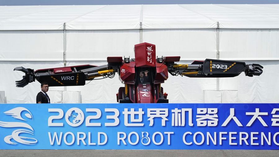 Pekerja mendemonstrasikan robot raksasa pada Konferensi Robot Dunia tahunan di Pusat Pameran dan Konvensi Internasional Etrong Beijing, Rabu, 16 Agustus 2023. (AP Photo/Ng Han Guan)