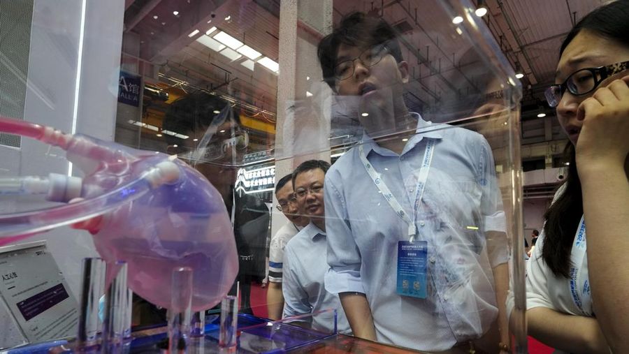 Pekerja mendemonstrasikan robot raksasa pada Konferensi Robot Dunia tahunan di Pusat Pameran dan Konvensi Internasional Etrong Beijing, Rabu, 16 Agustus 2023. (AP Photo/Ng Han Guan)