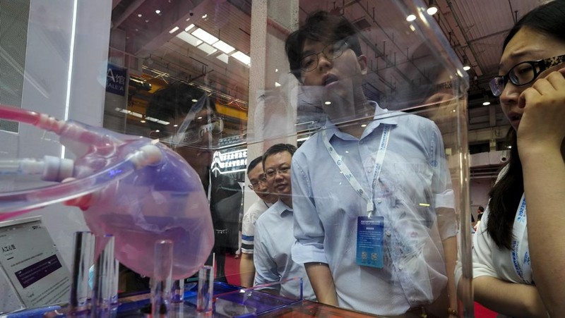 Pekerja mendemonstrasikan robot raksasa pada Konferensi Robot Dunia tahunan di Pusat Pameran dan Konvensi Internasional Etrong Beijing, Rabu, 16 Agustus 2023. (AP Photo/Ng Han Guan)