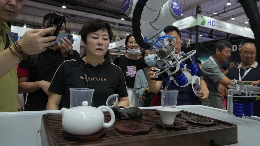 Pekerja mendemonstrasikan robot raksasa pada Konferensi Robot Dunia tahunan di Pusat Pameran dan Konvensi Internasional Etrong Beijing, Rabu, 16 Agustus 2023. (AP Photo/Ng Han Guan)